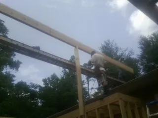 Carpenter setting a ridge beam over a new addition frame — Ice Dam Removal by Roofing Brothers in Dingle