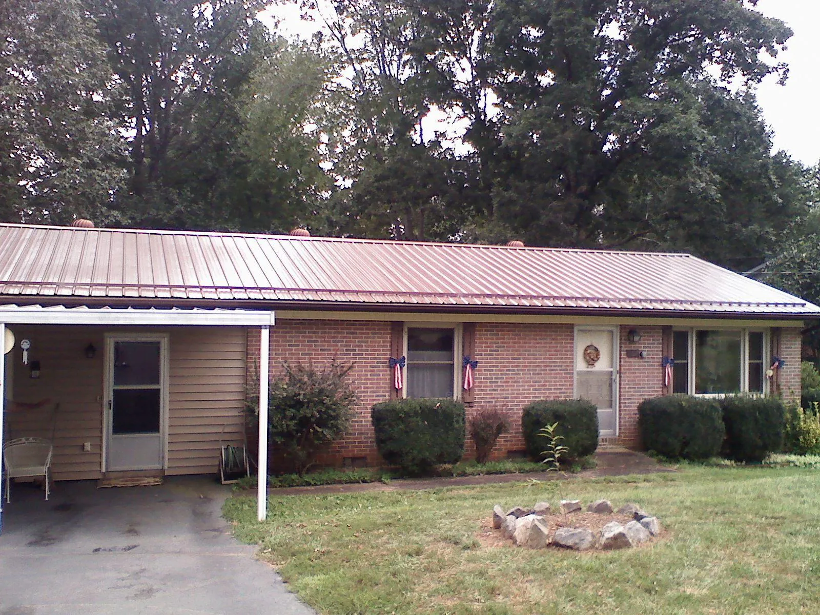 Bronze metal roof and carport on a brick ranch home — Roof Repair work by our crew in Dingle